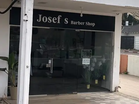 החזית של Josef’s Barber Shop עם השלט השחור